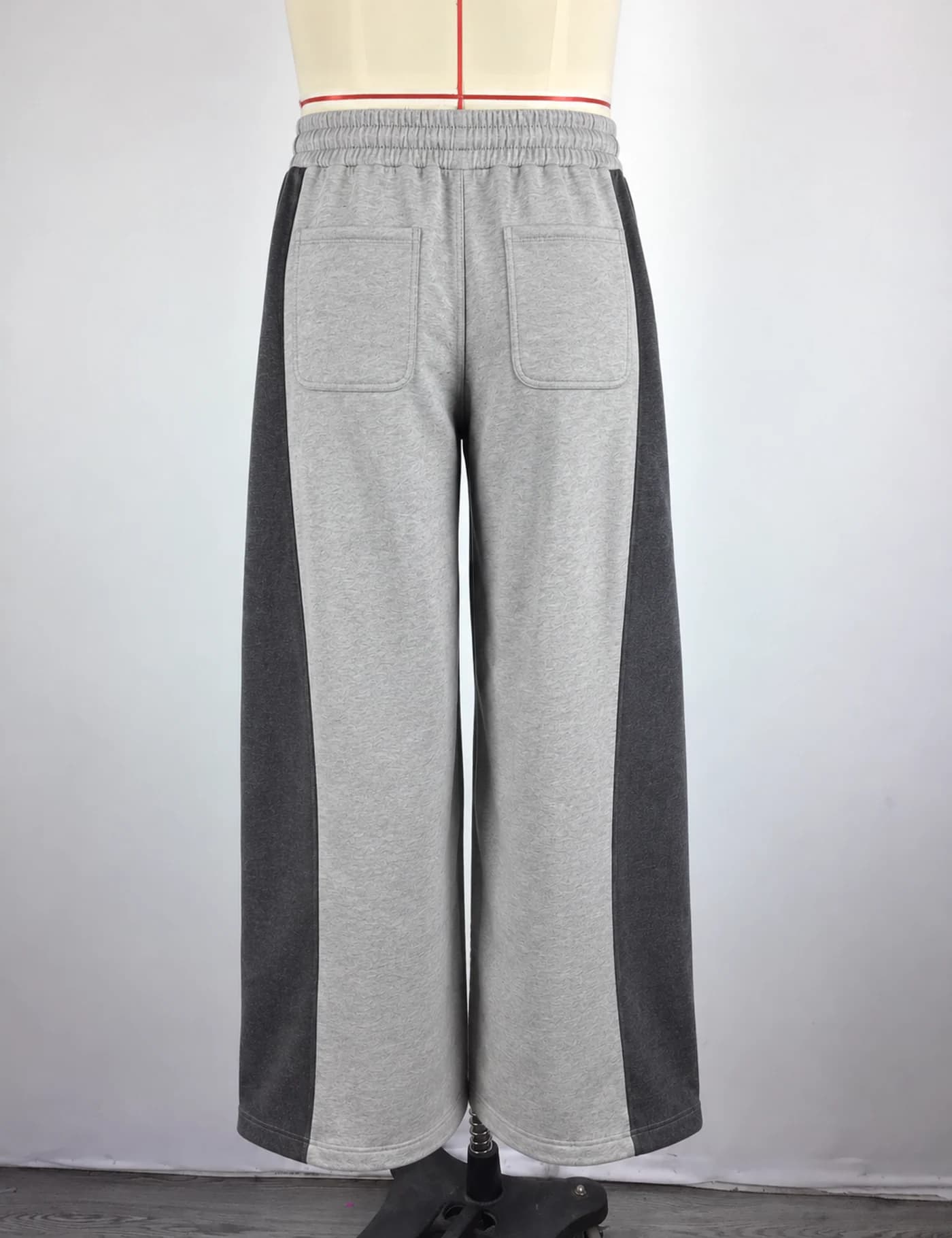 Actual two-tone side-panel wide-leg sweatpants sample shown from the back on a mannequin