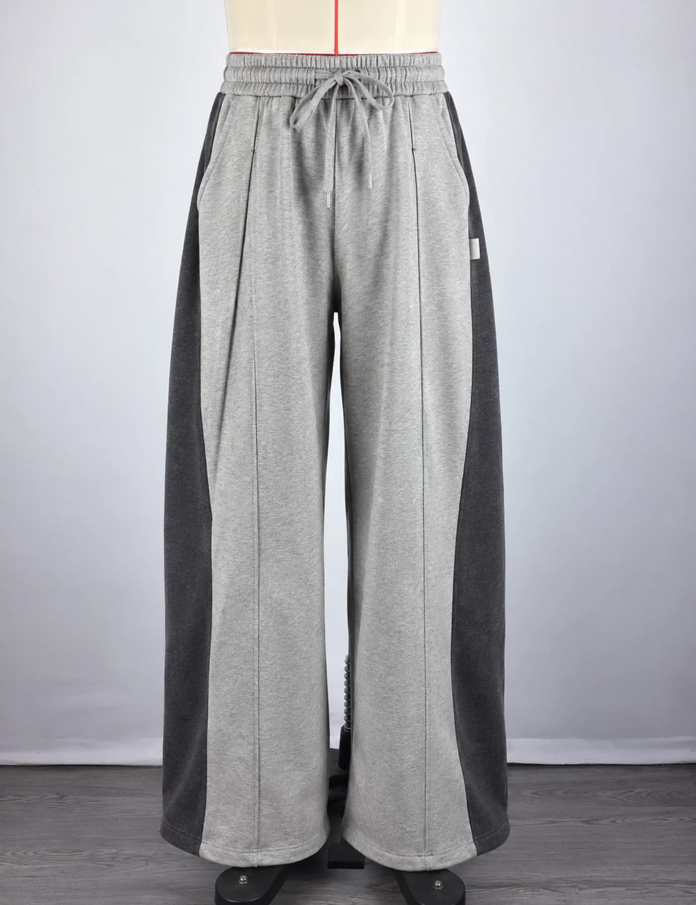 Actual two-tone side-panel wide-leg sweatpants sample shown from the front on a mannequin