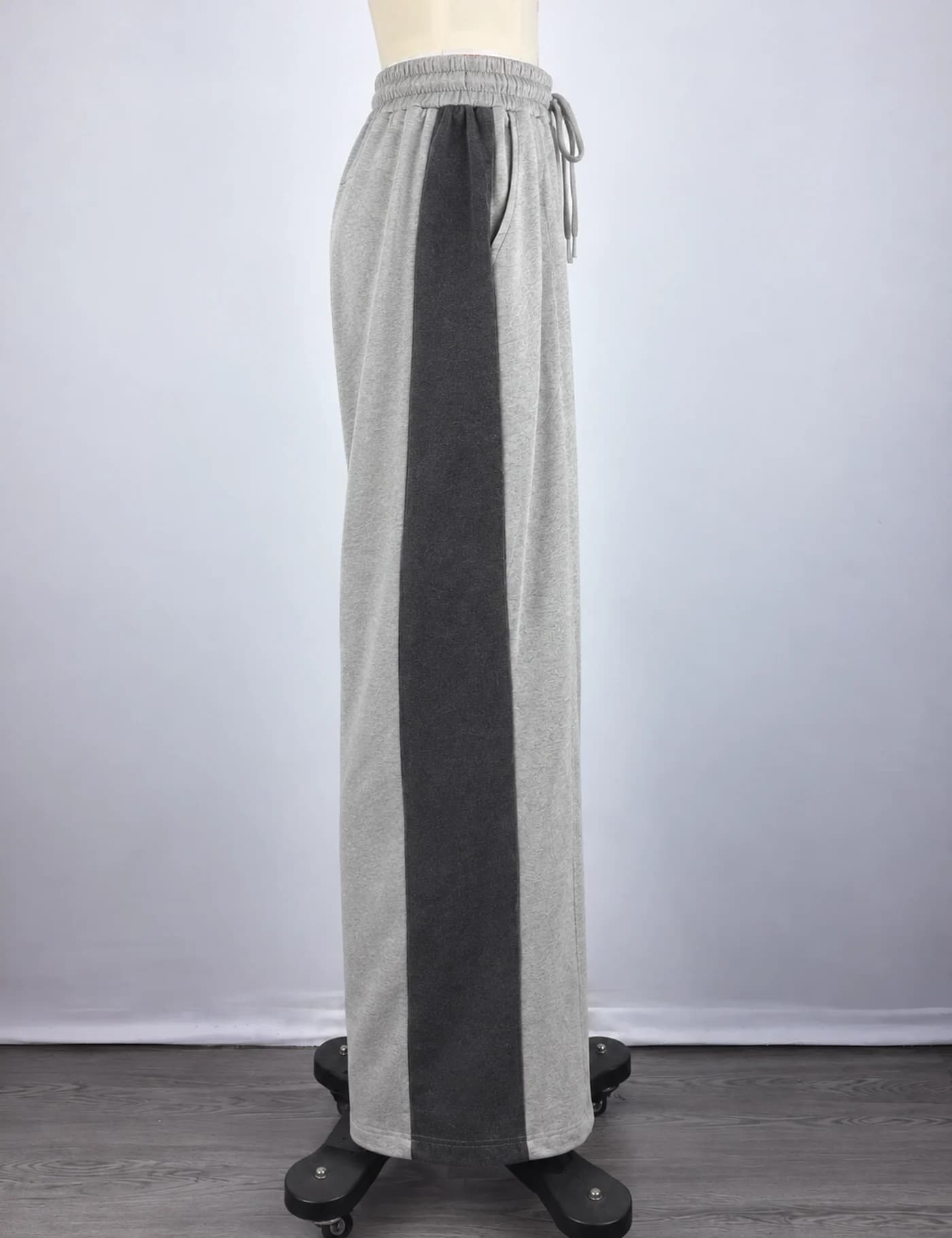 Actual two-tone side-panel wide-leg sweatpants sample shown from the side on a mannequin