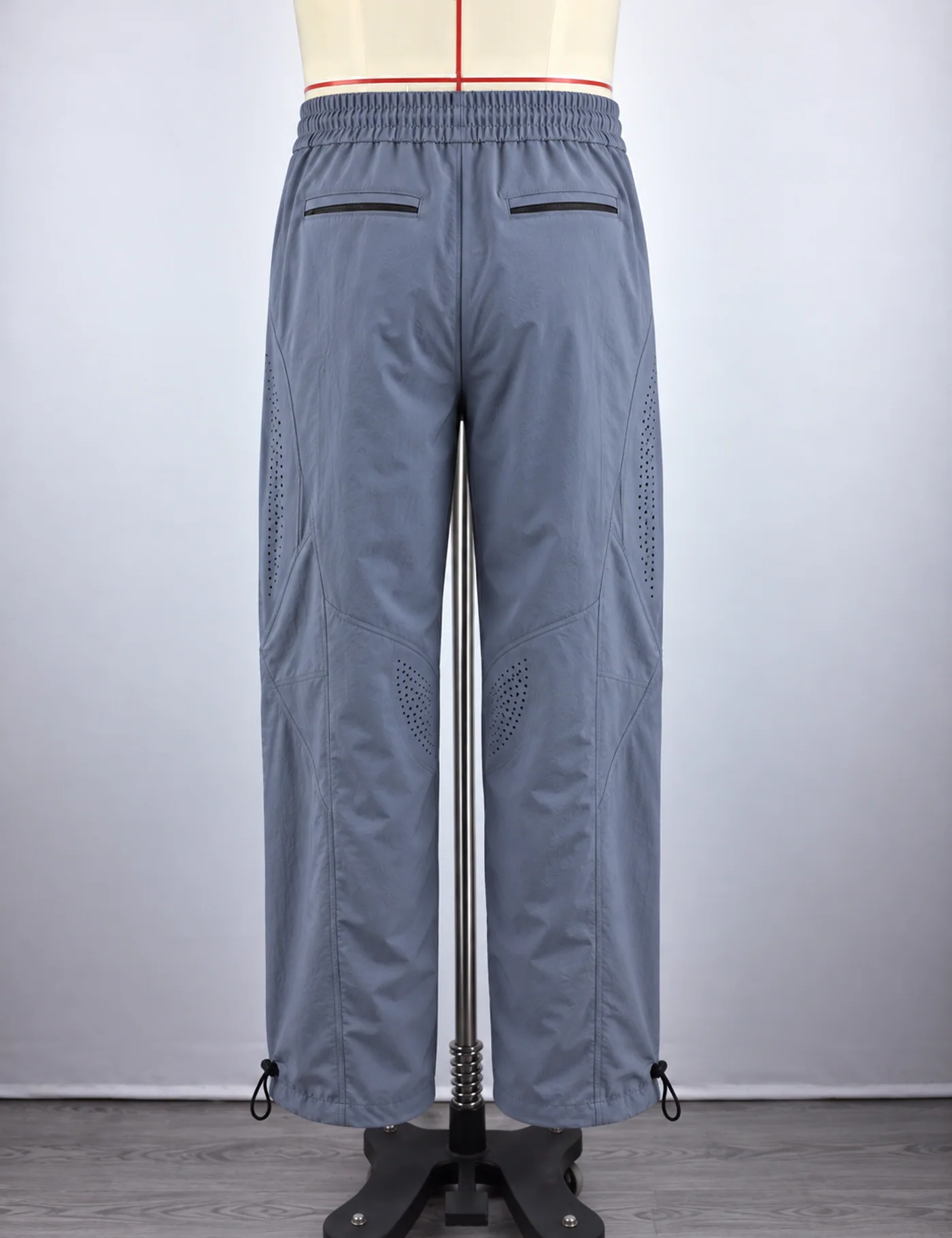 Actual ventilated wide-leg track pants sample shown from the back on a mannequin