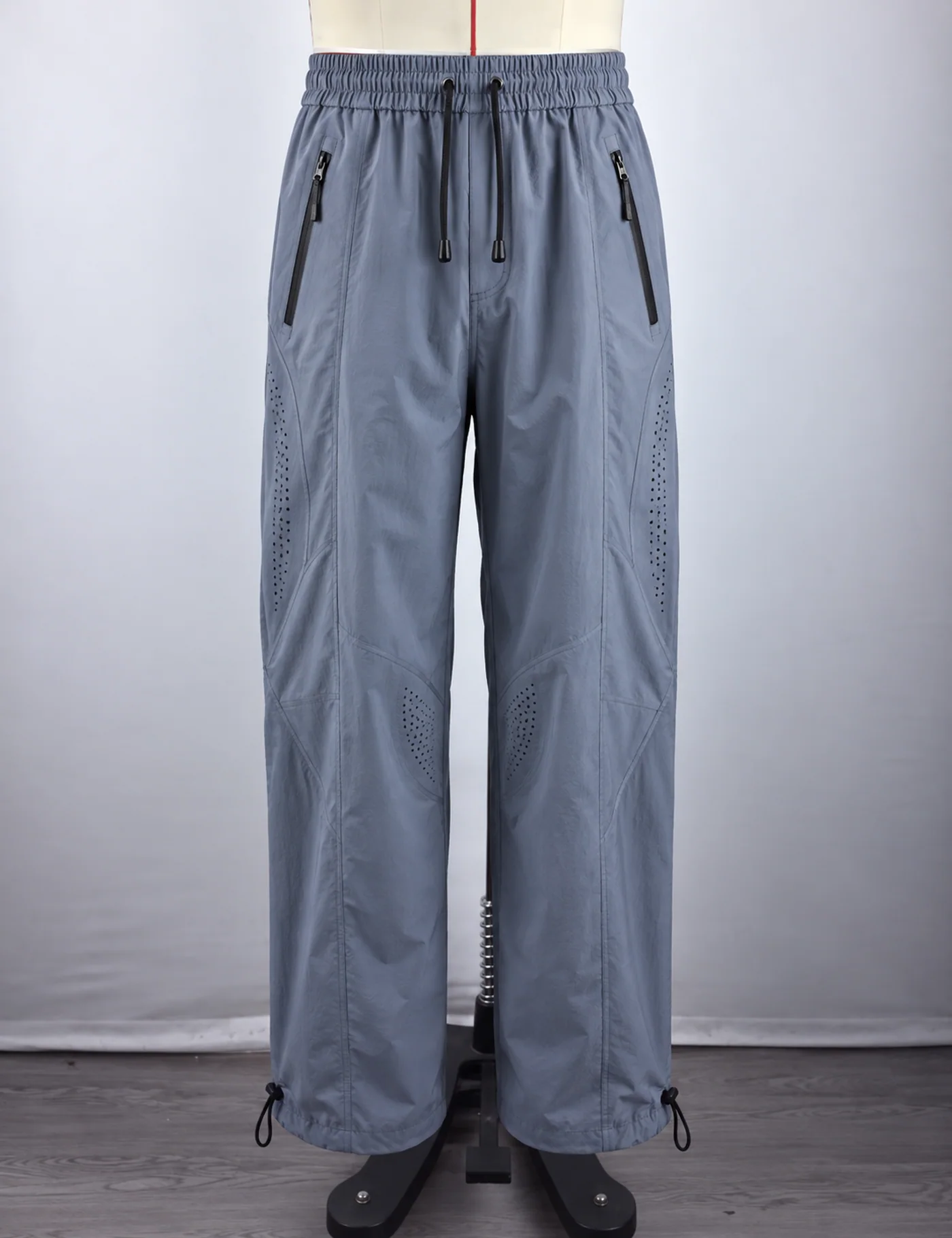 Actual ventilated wide-leg track pants sample shown from the front on a mannequin