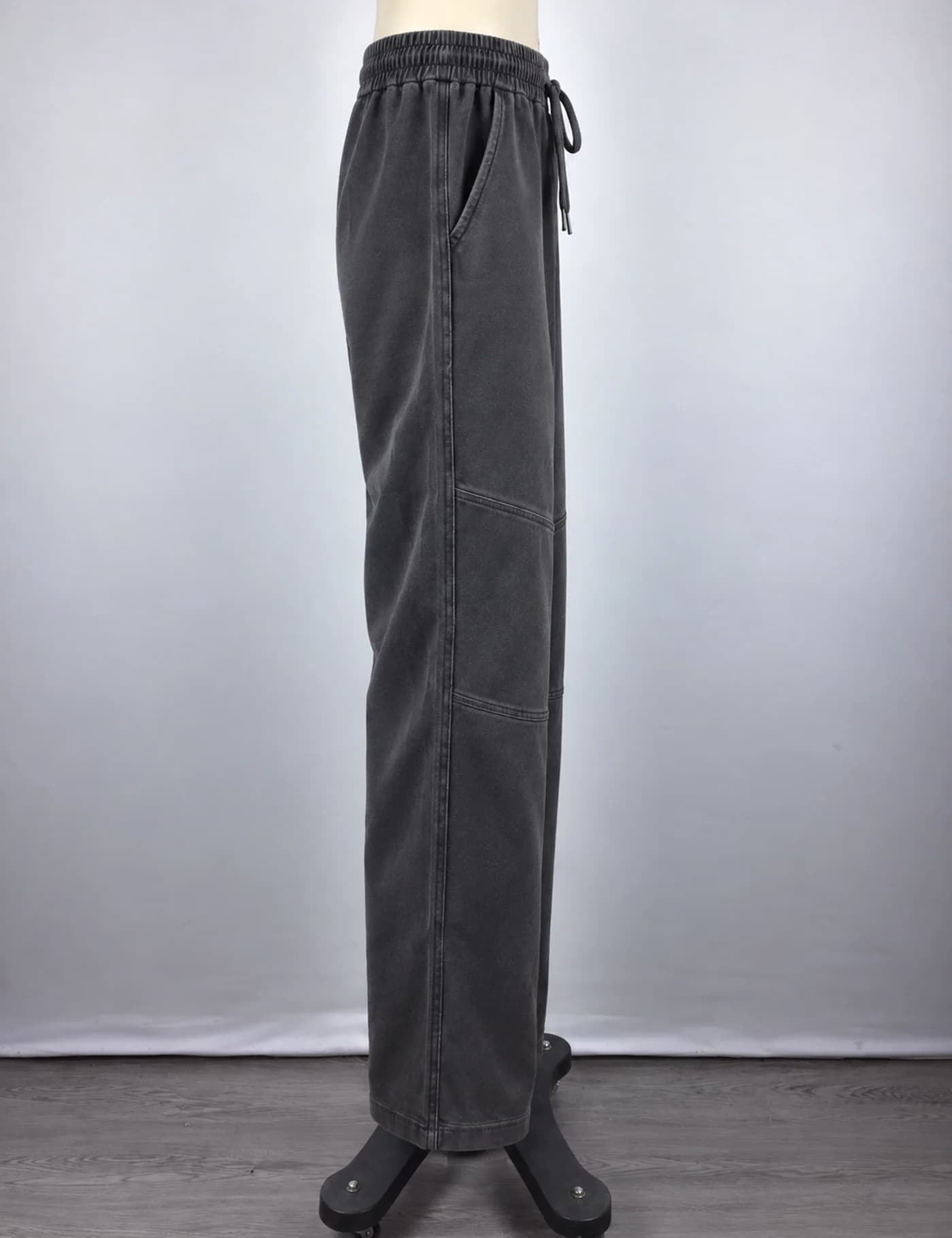 Actual washed articulated-knee wide-leg sweatpants sample shown from the side on a mannequin