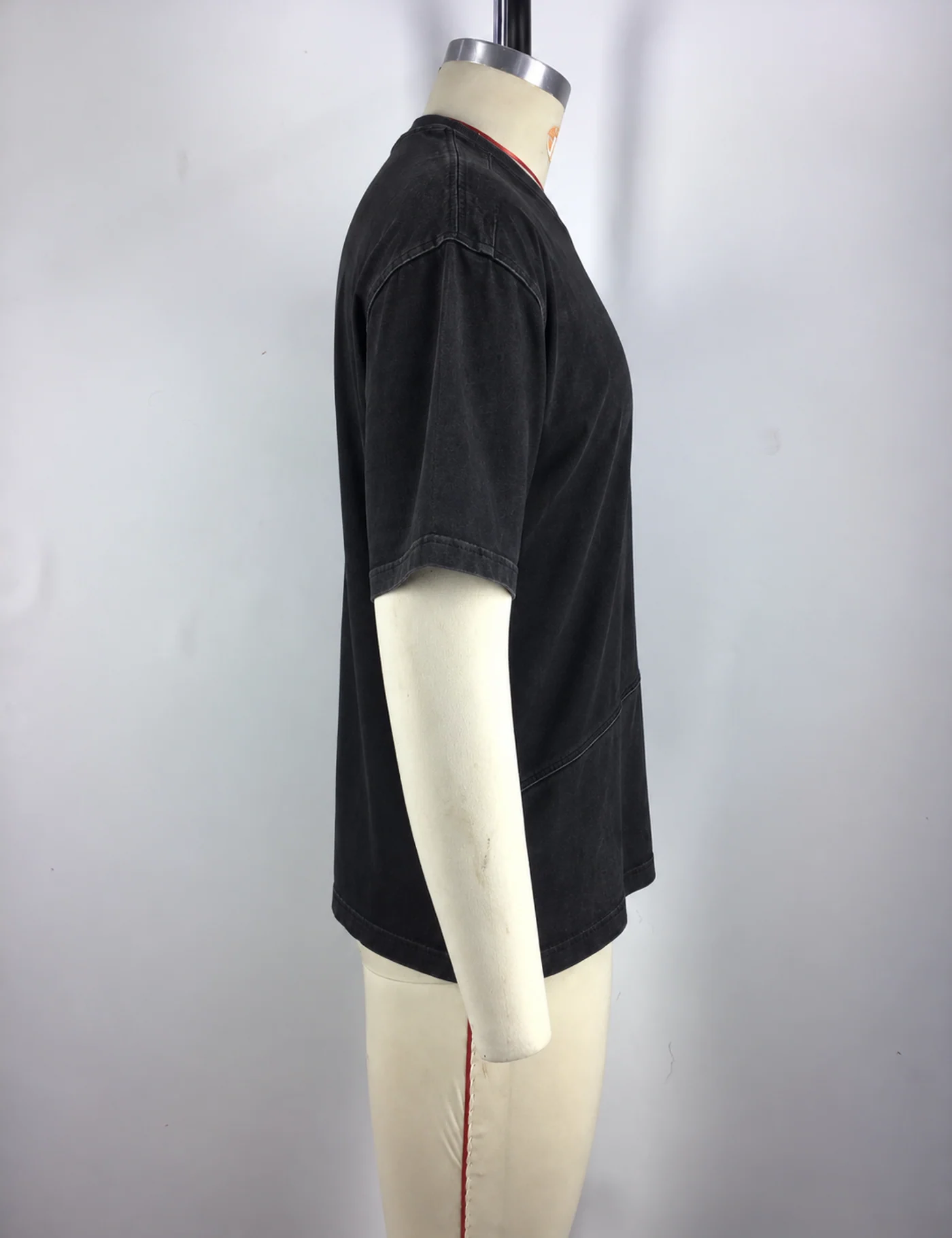 Actual washed asymmetric-seam oversized t-shirt sample shown from the side on a mannequin