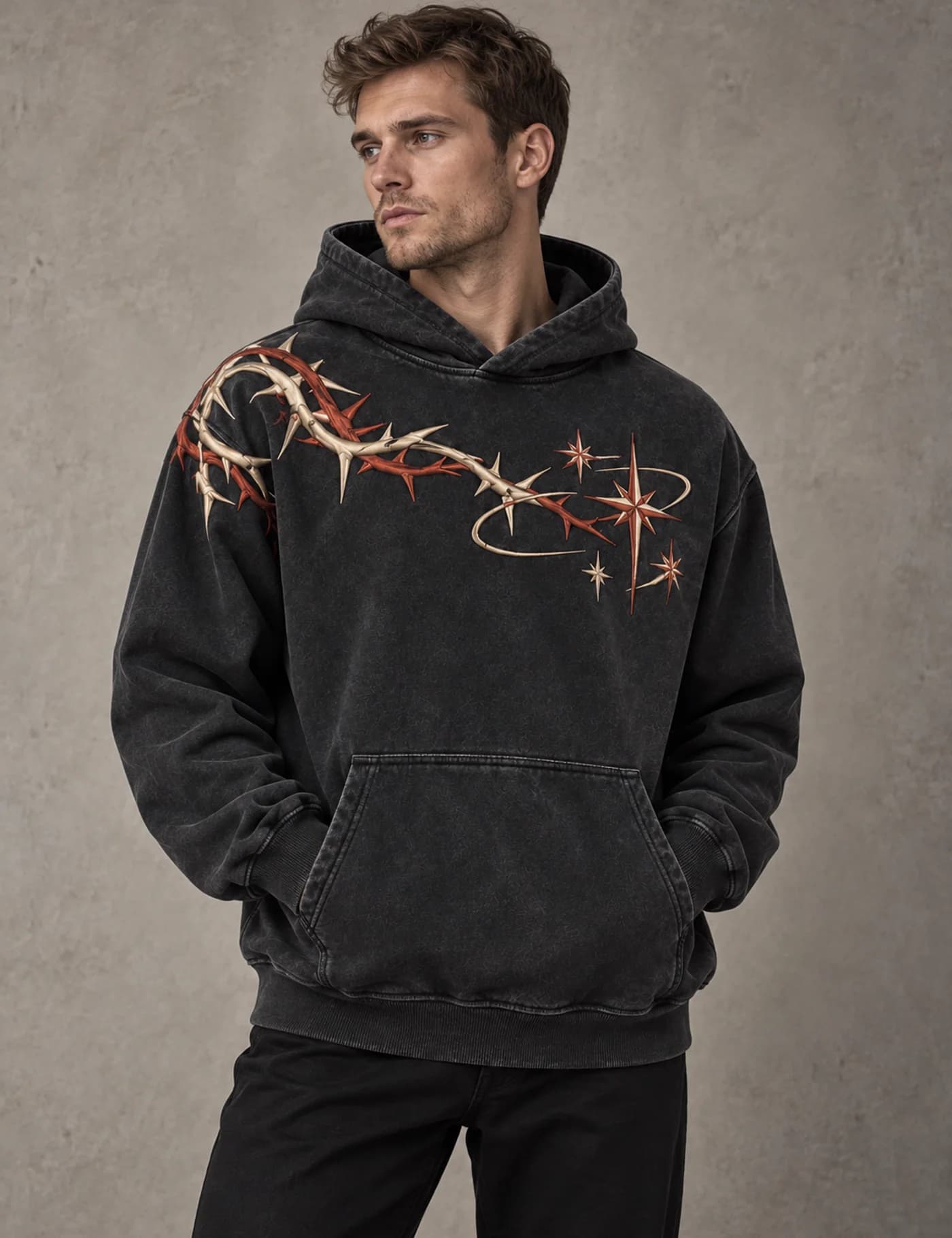 Male model wearing a charcoal washed hoodie with rust and cream raised barbed-vine decoration