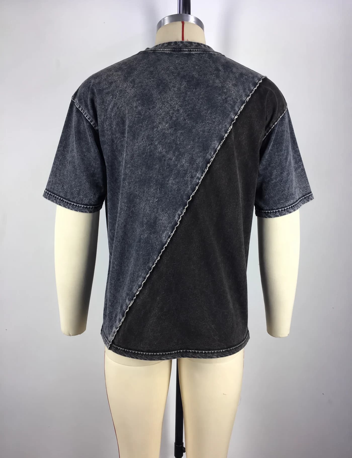 Actual washed contrast-panel t-shirt sample shown from the back on a mannequin
