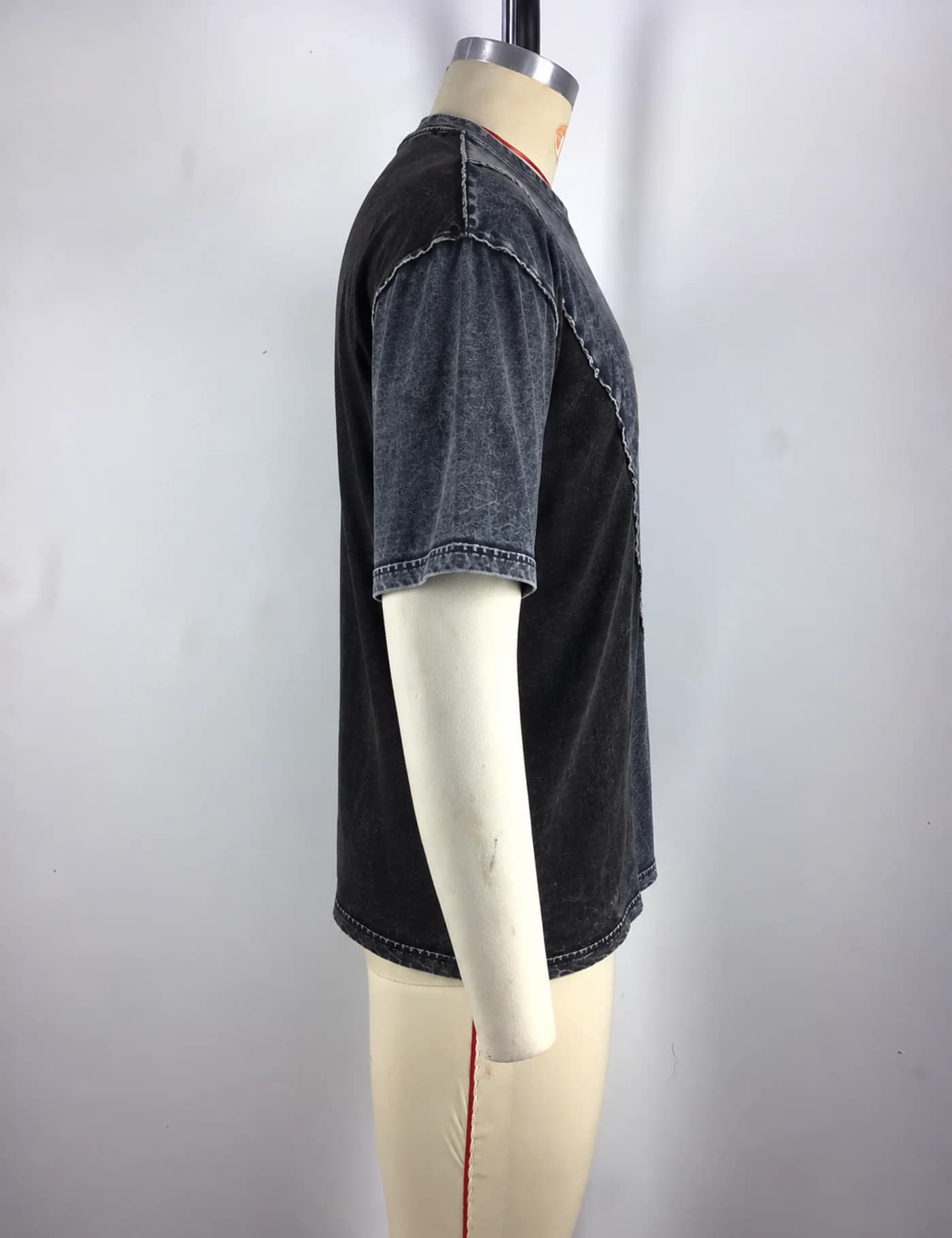 Actual washed contrast-panel t-shirt sample shown from the side on a mannequin