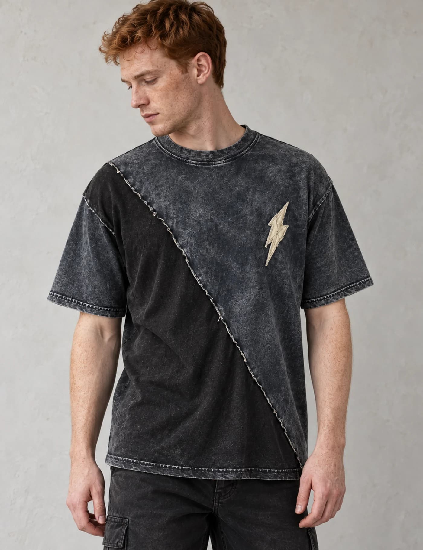 Red-haired male model wearing a washed black asymmetric contrast-panel T-shirt