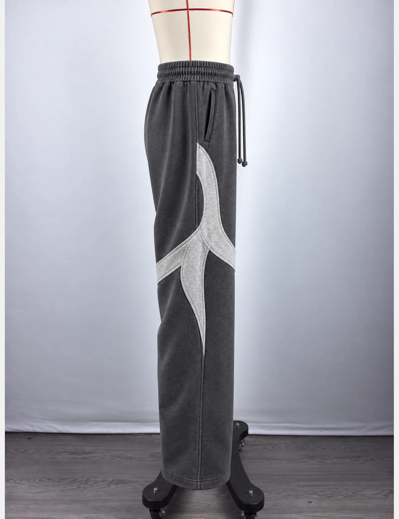 Actual washed curved-panel wide-leg sweatpants sample shown from the side on a mannequin