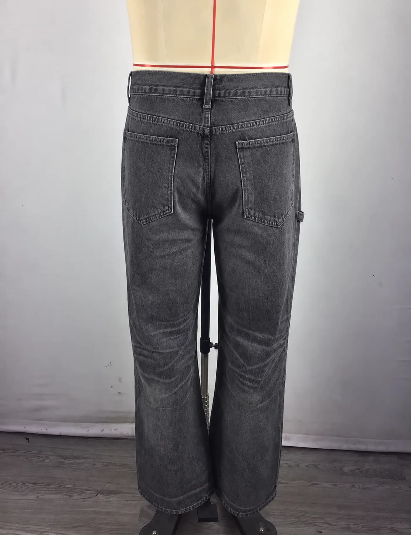 Actual washed panel-knee carpenter jeans sample shown from the back on a mannequin