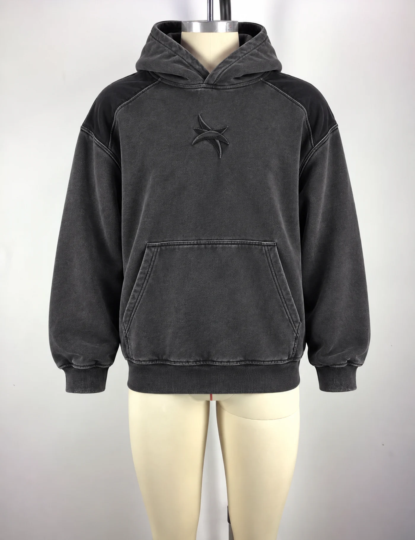 Charcoal washed pullover hoodie on a mannequin with tonal chest decoration and a continuous kangaroo pocket
