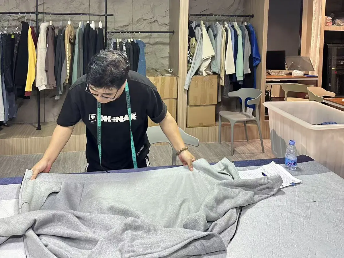 KAOUYOU QC personnel measuring garment dimensions