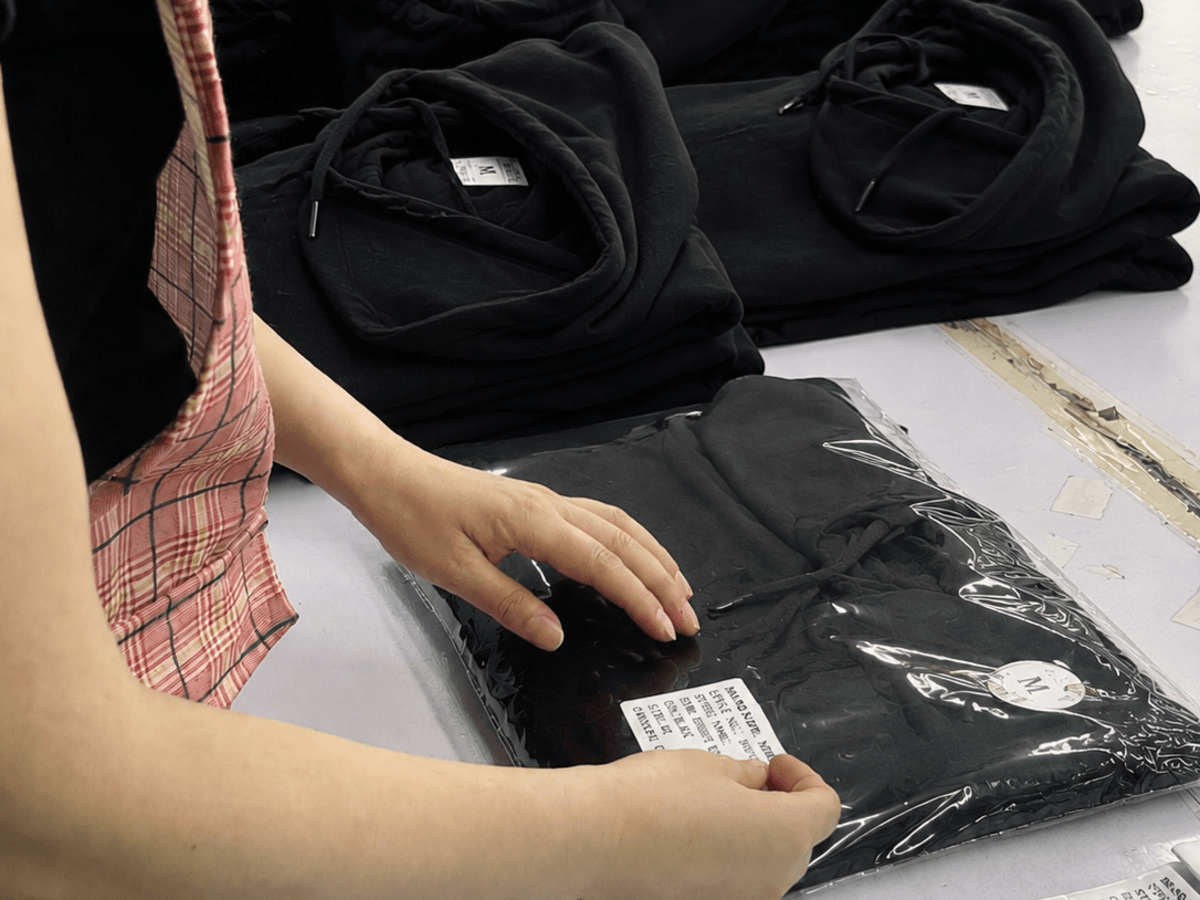 KAOUYOU staff checking packed garments and carton information before shipment